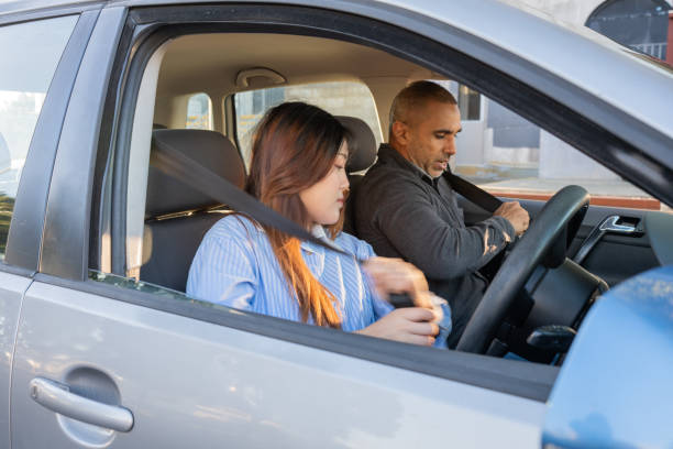 istock Young Driver and Passenger Putting on Seat Belts 2160953882