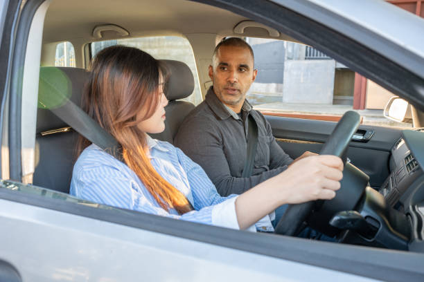 istock Female Learner Driver Listens To Driving Inspector 2160953887