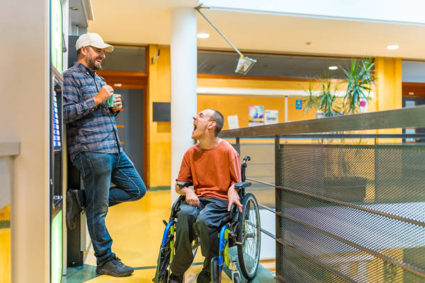 istock Man with disability and coworker next to a vending machine 2160956116