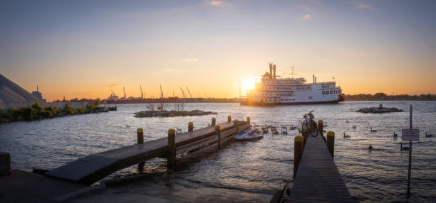 A passenger nautical vessel on the Detroit River at sunset.   Photo taken from Windsor, Ontario.