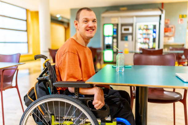 istock Man with disability sitting drinking water in the university cafeteria 2160956938
