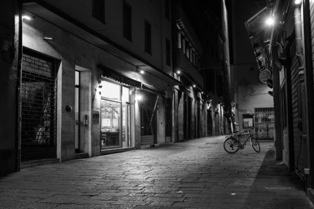 Bologna, Italy - June 15 2024: Night Street Scene on Via Altabella in the Old Town of Bologna with Cobblestones and Bicycle