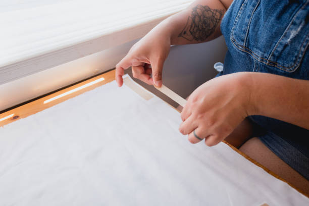 istock Hispanic Woman Cheerfully Making Pillow Case with Fabric Tape 2160961617