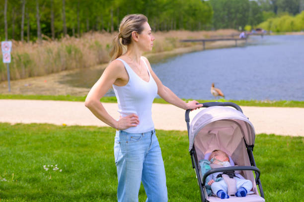 istock Mother with Baby Stroller by the Lake 2160965767