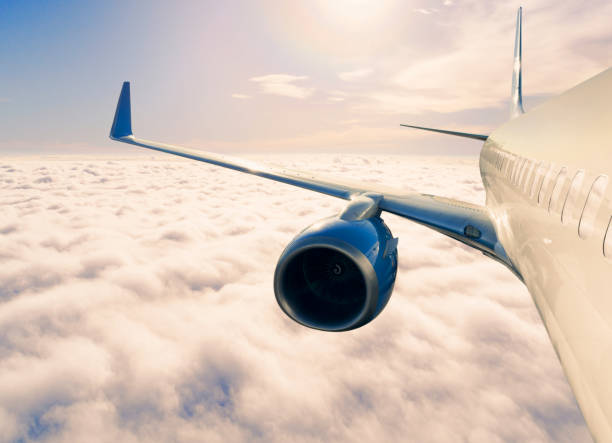 istock Passengers commercial airplane flying above clouds in sun light. Flying above clouds in dramatic sun light. Airplane in the sky. Detail of commercial jet airplane flying above clouds 2160966863