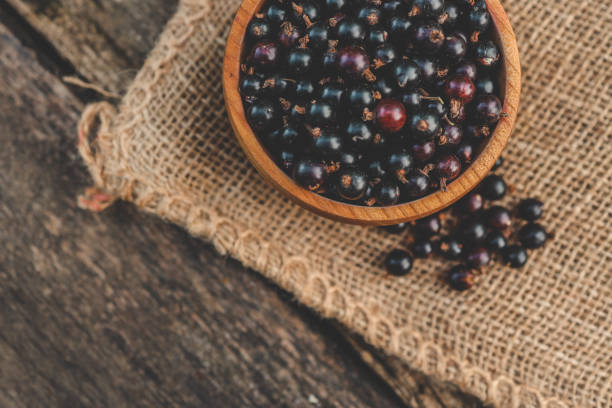 istock Black currant in a wooden bowl on nature 2160971184