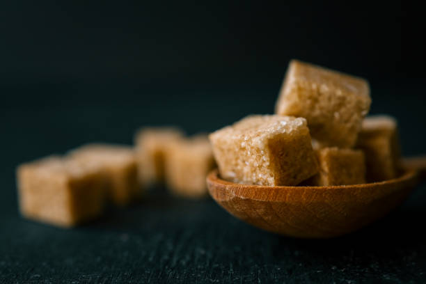 istock brown sugar heap and wooden spoon 2160974137