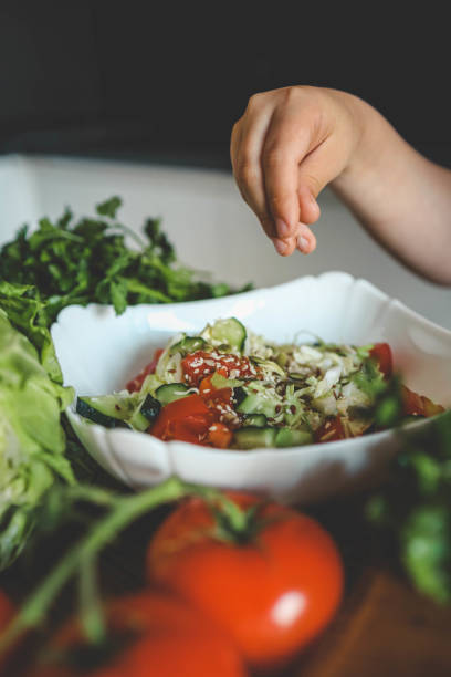 istock Preparing vegetable salad, sprinkle flax and sesame seeds 2160974520