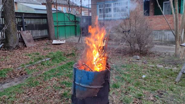istock Branches and debris burn in the barrel. House yard cleaning. 2160977034