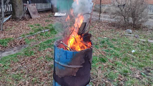 istock Branches and debris burn in the barrel. House yard cleaning. 2160977039