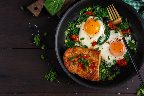 istock Keto breakfast. Fried eggs  with spinach and toast. Top view, flat lay 2160977283