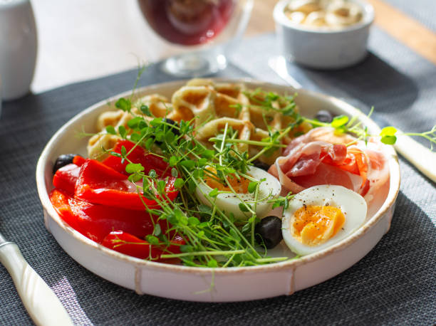 istock English breakfast. Boiled egg, jamon, waffles and green herbs. 2160978497