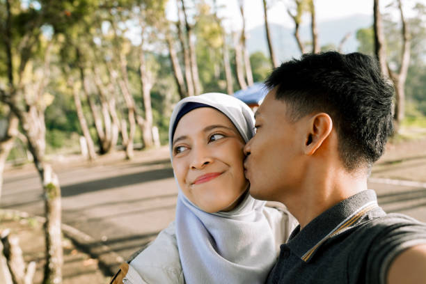 Young couple are smiling for a selfie together. Cheerful couple taking a selfie