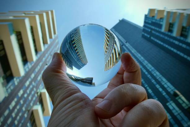 Hand holding crystal ball with skyscrapers background