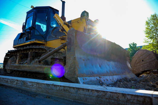 Wheel loader silhouette are digging soil with bucket lift up in the construction site on white  background