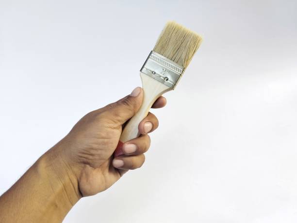 istock Hand holding a paint brush isolated in white background 2160985141