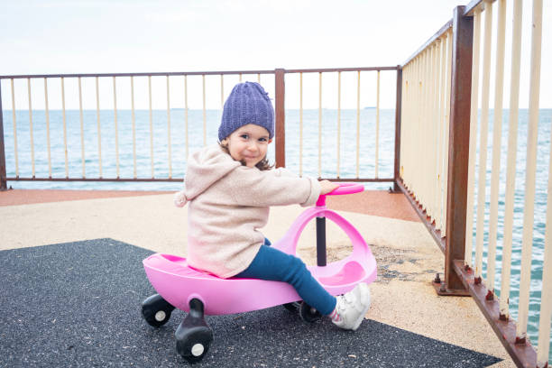 Three years old child riding her swing car