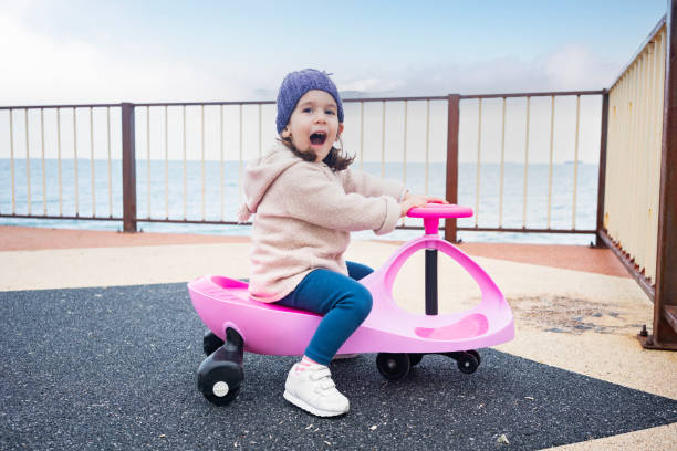 Three years old child riding her swing car