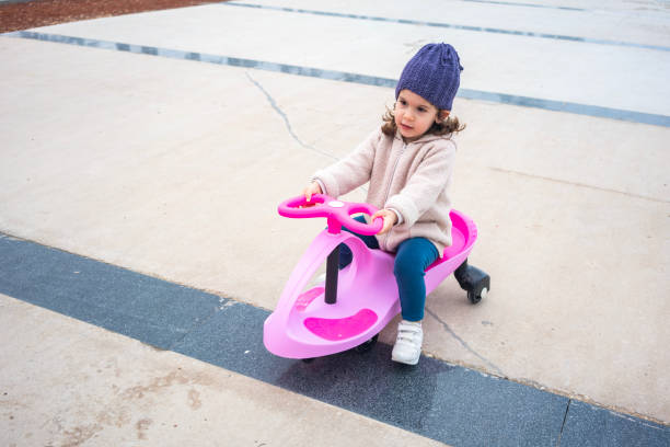 Three years old child riding her swing car