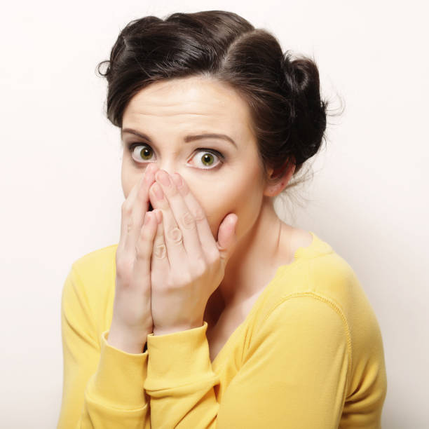 istock Young woman with hands over mouth. 2160986993