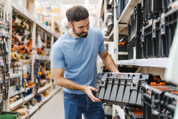 istock Smiling young man choosing instruments for repair holding black box 2160987080
