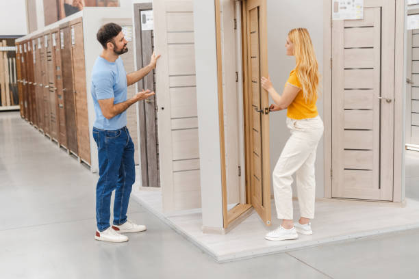 istock Happy young couple discussing choosing interior door while standing in the hardware store 2160987889