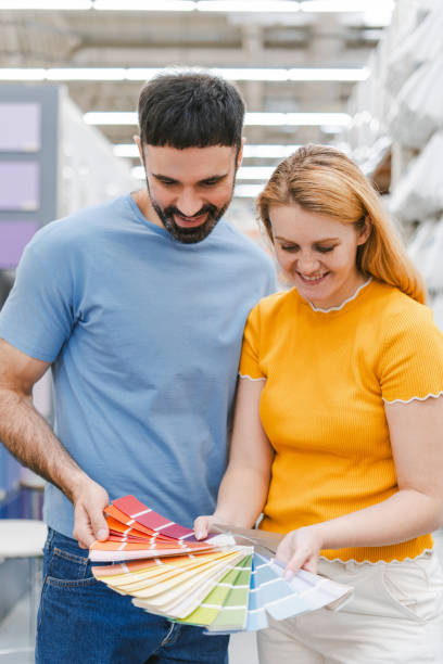 istock Happy man and woman choosing paint color from samples for new interior design 2160987901