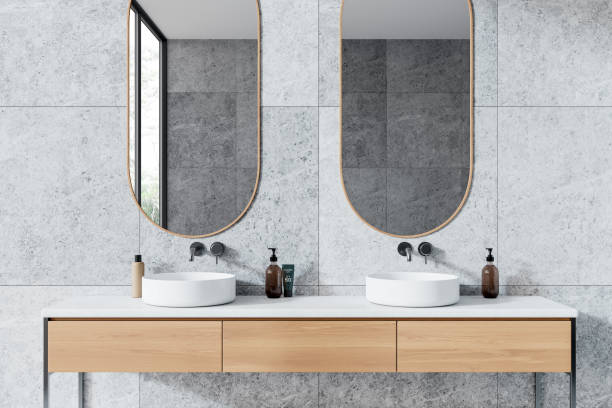 istock Modern bathroom with twin sinks and mirrors, minimalistic design. Stone wall background. Concepts of interior design and home decor.  3D Rendering 2160988278
