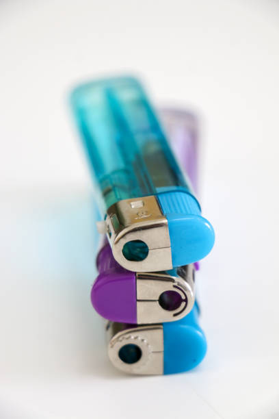 istock Vertical shot of stack of three lighters, two blue, one purple. Useful tool to ignite a variety of flammable items, such as cigarettes, butane gas, fireworks, candles, or campfires. 2160988794