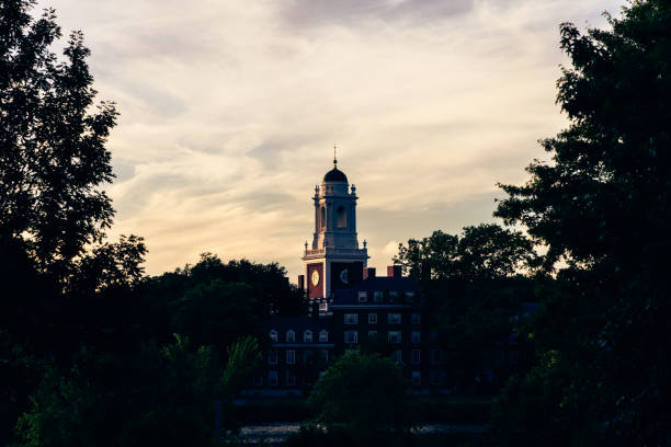 Cambridge, Massachusetts, USA -  July 3, 2024: Early evening sunset over the Charles River and the Eiiot House buildings of Harvard University's Cambridge campus. Eliot House is one of the twelve undergraduate residential Houses at Harvard University. It is one of the seven original houses at the college. Opened in 1931, the house was named after Charles William Eliot, university president from 1869 to 1909.
