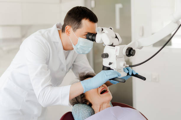 istock Professional dentist doctor, man treating teeth using dental microscope, checking senior woman 2160991550
