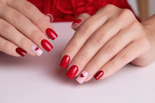 istock Female hands with red manicure nails, heart design 2160992954