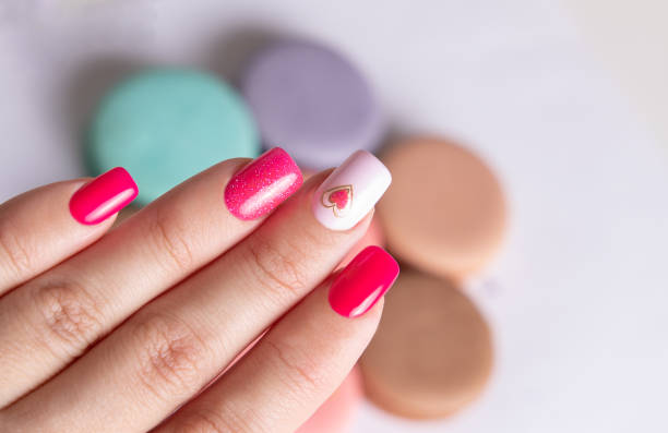 istock Female hand with pink manicure nails, heart design 2160993128