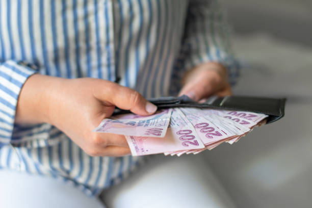 Leather wallet with money in the hands of a woman who takes out a pack of 200 Turkish lira bills from wallet, a lot of money but little value Leather wallet with money in the hands of a woman who takes out a pack of 200 Turkish lira bills from wallet, a lot of money but little value, high inflation in Turkey minimum wage stock pictures, royalty-free photos & images