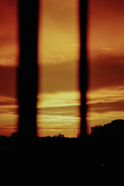 in silhouette Sunset looking through window at city with reflection on window with sunset