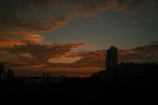 City in silhouette during sunset with dramatic sky