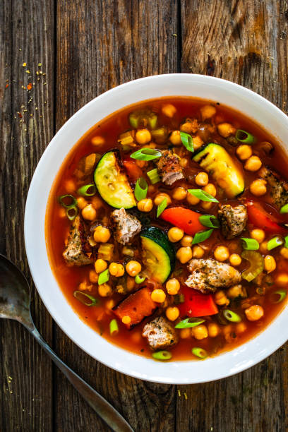 istock Fresh vegetable soup with meat, chickpeas and lentil on wooden table 2160994569