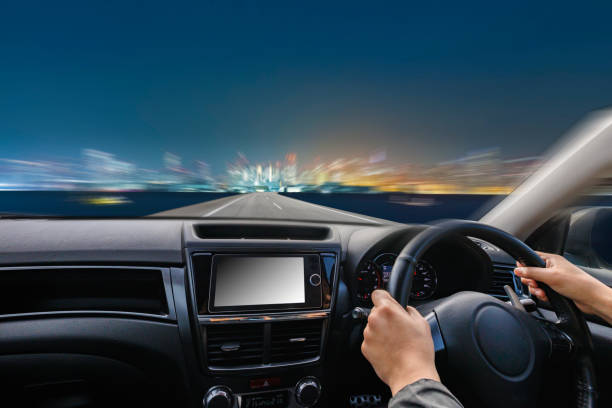 istock Image of a car driving on a road at dusk 2160996087