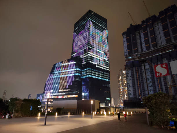 People walking on the modern developing area by the Airside skyscraper, height 207 mt, an under construction building in Kai Tak, Kowloon City district. Hong Kong