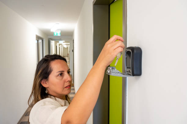 Woman on European Trip with Son Retrieving Key from Hostel Lockbox A scene of a woman traveling with her son, retrieving the key from a lockbox at their hostel. This highlights an alternative accommodation option, offering a flexible and budget-friendly way to explore Europe while experiencing unique and communal lodging. key package stock pictures, royalty-free photos & images