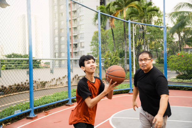 istock Father Teaching Son How to Play Basketball 2161000142