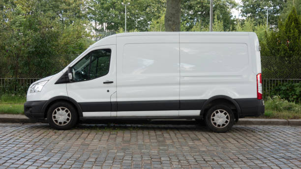 istock White Delivery Van Parked on Cobblestone Street 2161005179