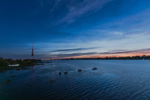 Riga panorama with television tower, Daugava river and Noctilucent clouds above before the sunrise on July night