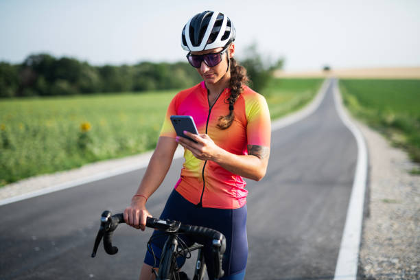 istock Woman using her cellphone while out cycling on a road. 2161010835