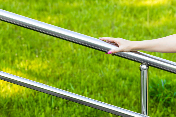 istock woman's hand holding onto the metal staircase railing. 2161011750