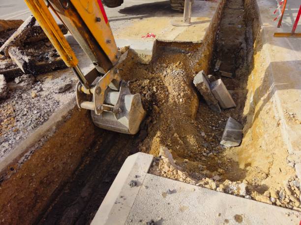 istock Bulldozer digging trench in construction site on city street 2161014905