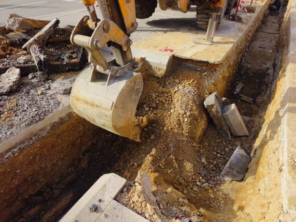 istock Bulldozer digging trench in construction site on city street 2161014907