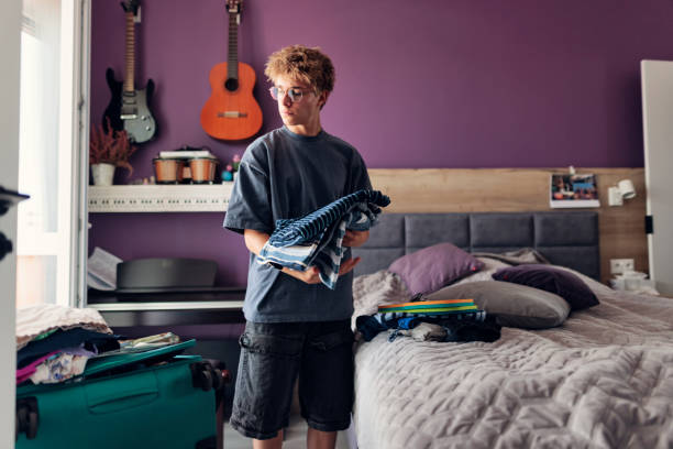 istock Teenage boy is packing for summer vacations. 2161014985