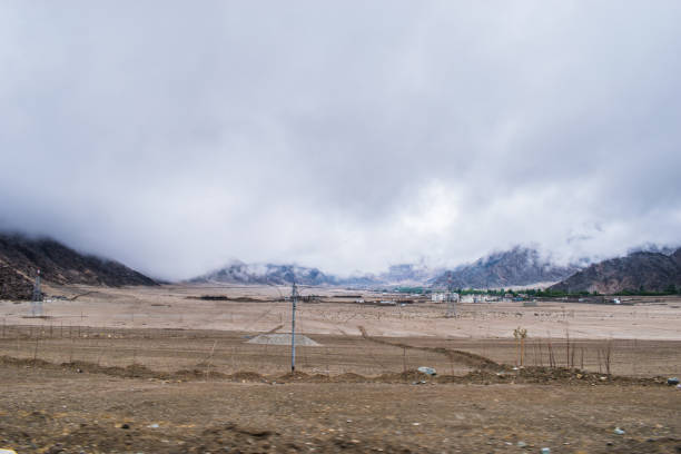 Travel forward concept background road on plains in Himalayas with mountains and dramatic clouds. Leh road, Ladakh Jammu and Kashmir India.