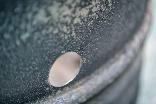 An external hole in an old oil drum being used as a burning container